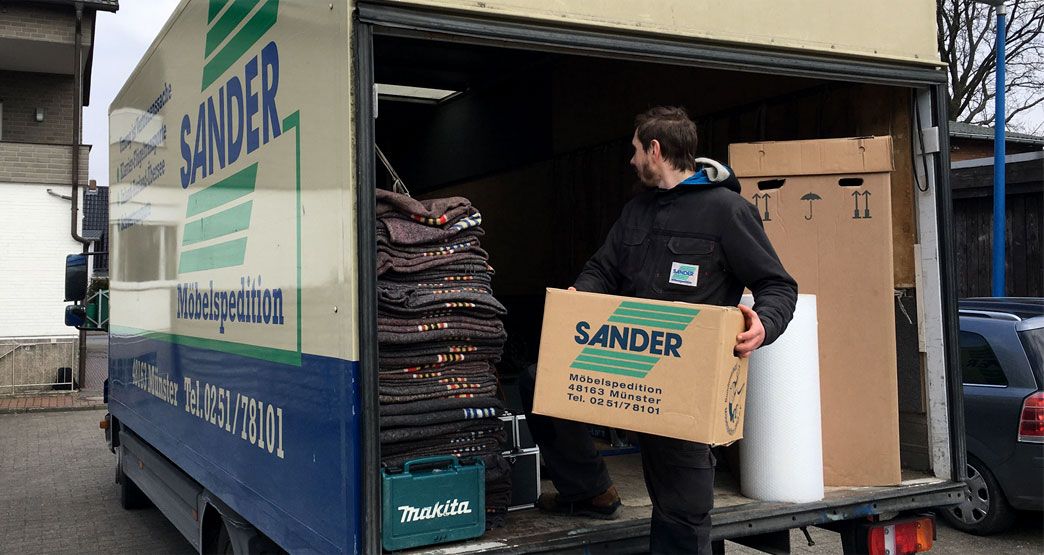 Ein Mann der Sander GmbH belädt den Transporter